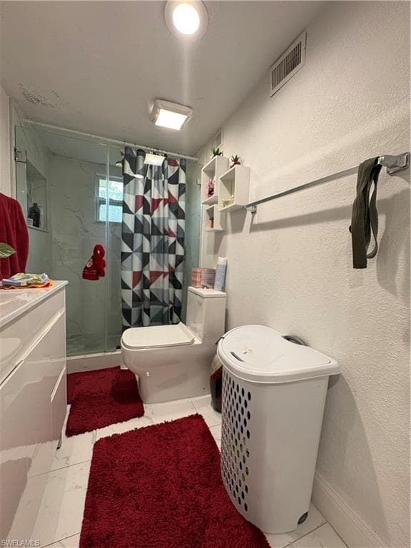 Bathroom featuring a glass-enclosed shower, white tile flooring, and a modern vanity with a white countertop