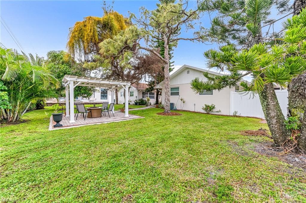 View of yard with a pergola and fire pit