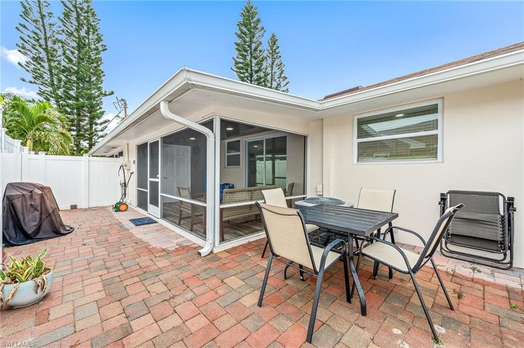 View of patio featuring a sunroom