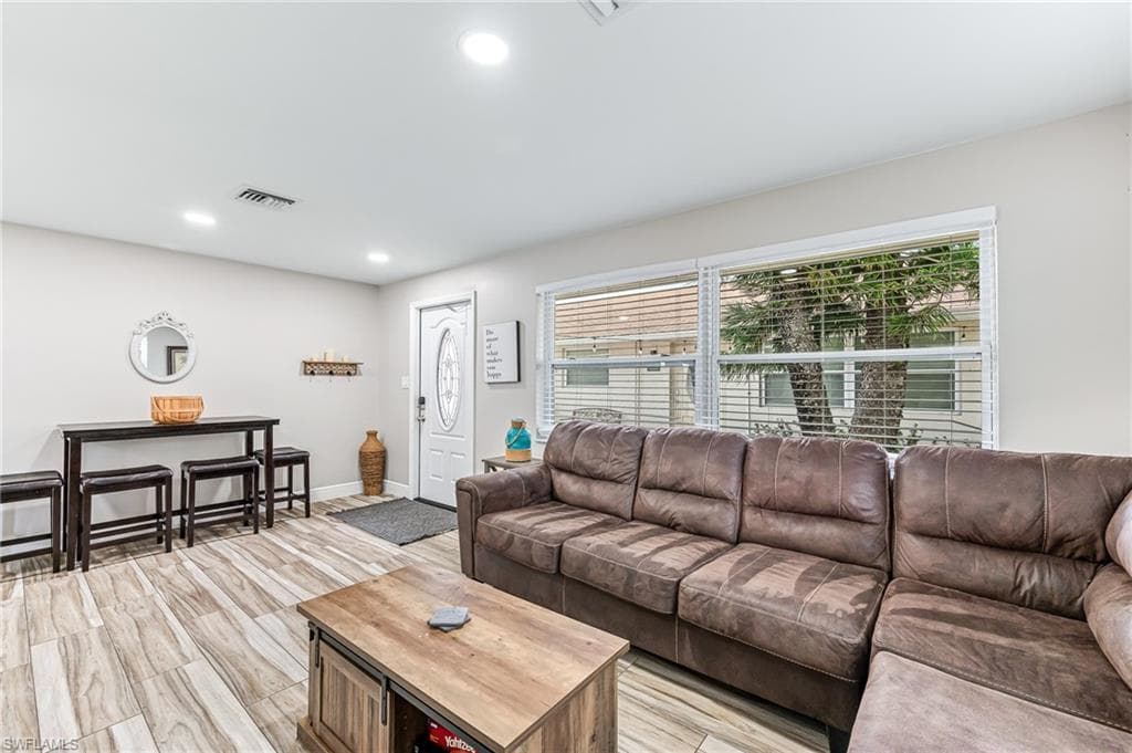 Living room with light wood-type flooring and a wealth of natural light