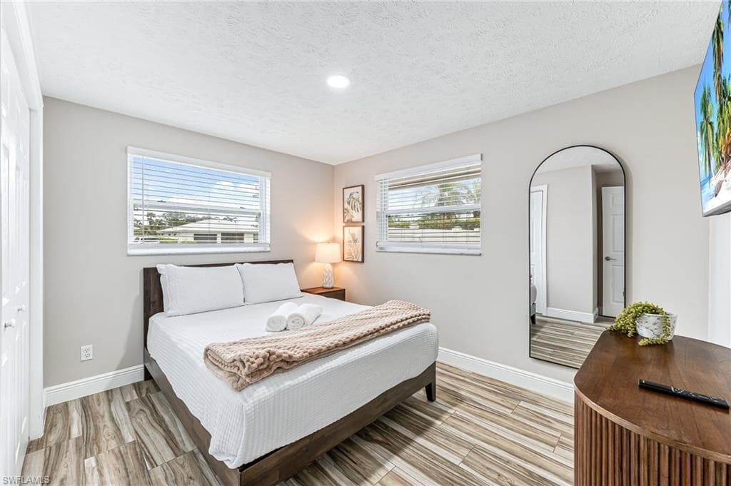 Bedroom featuring a closet, light hardwood / wood-style flooring, and a textured ceiling