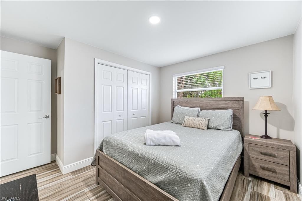 Bedroom featuring light wood tile flooring and a closet