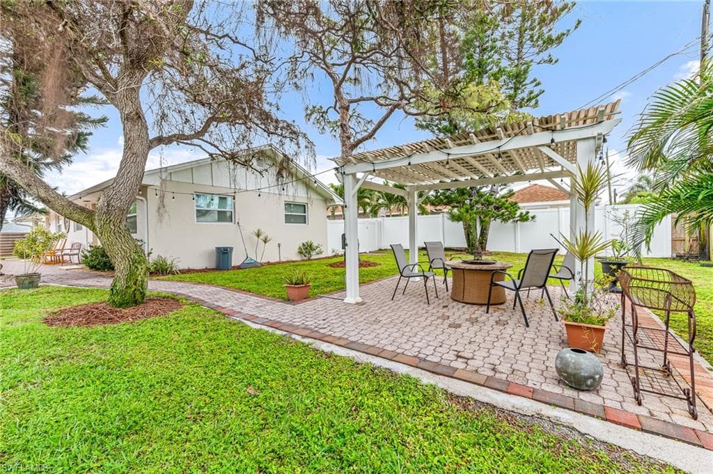 View of yard featuring a pergola, a fire pit, and a patio area