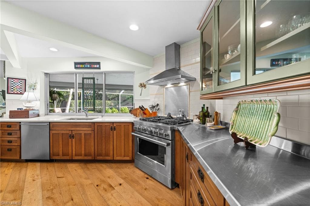 Bright, open living area with warm wood flooring, abundant natural light, and views toward the screened pool and lanai.