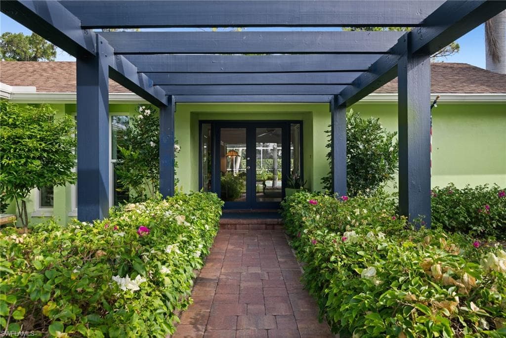 The updated kitchen is equipped with a gas stove, glass-fronted cabinets, and quartz countertops, and overlooks the outdoor retreat beyond.