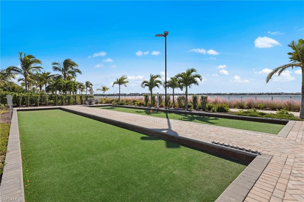 Bocce ball court featuring synthetic turf, paver pathways, and a perimeter of manicured landscaping