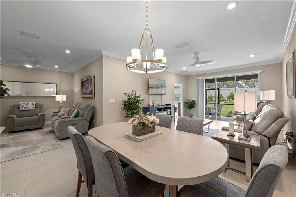 Dining space with a contemporary chandelier, recessed lighting, and crown molding.
