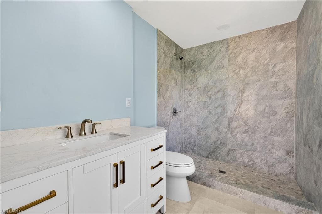 Bathroom featuring a single vanity with a white countertop and bronze-finish hardware