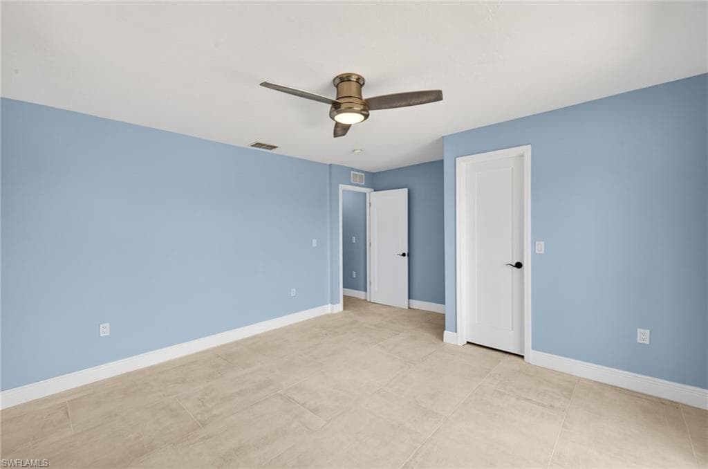 Bedroom #2 featuring light blue walls, ceramic tile flooring, and white baseboards