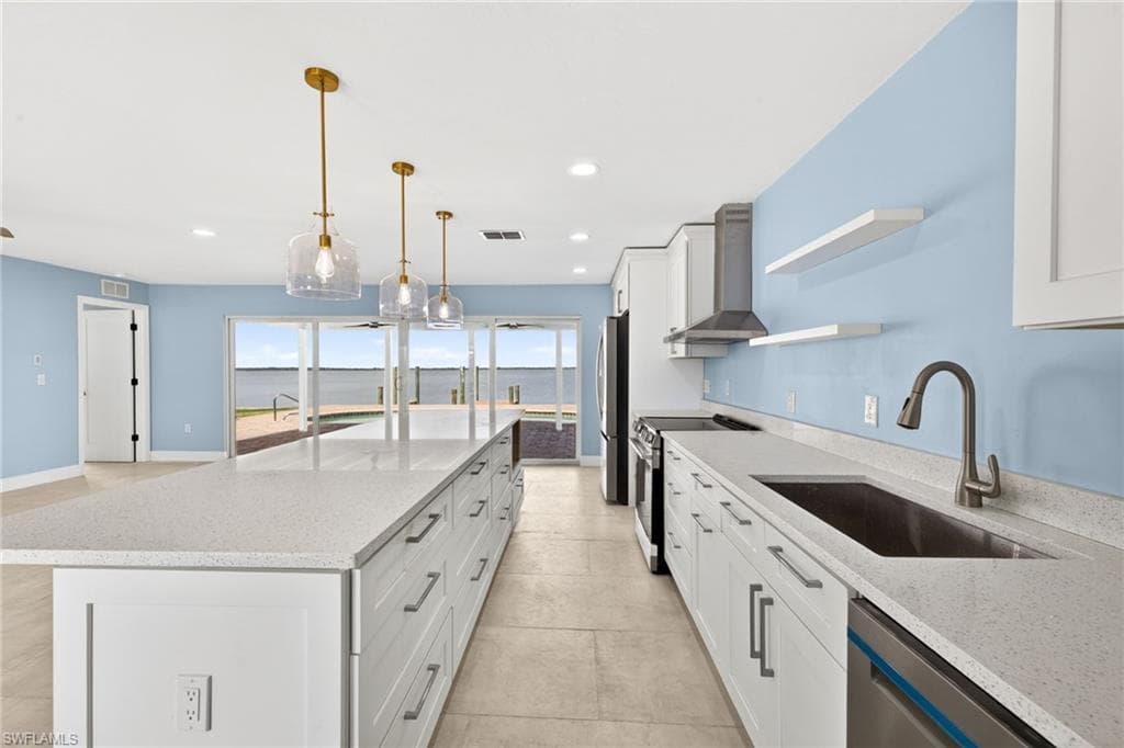 Kitchen with a large central island featuring white cabinetry and light-colored countertops