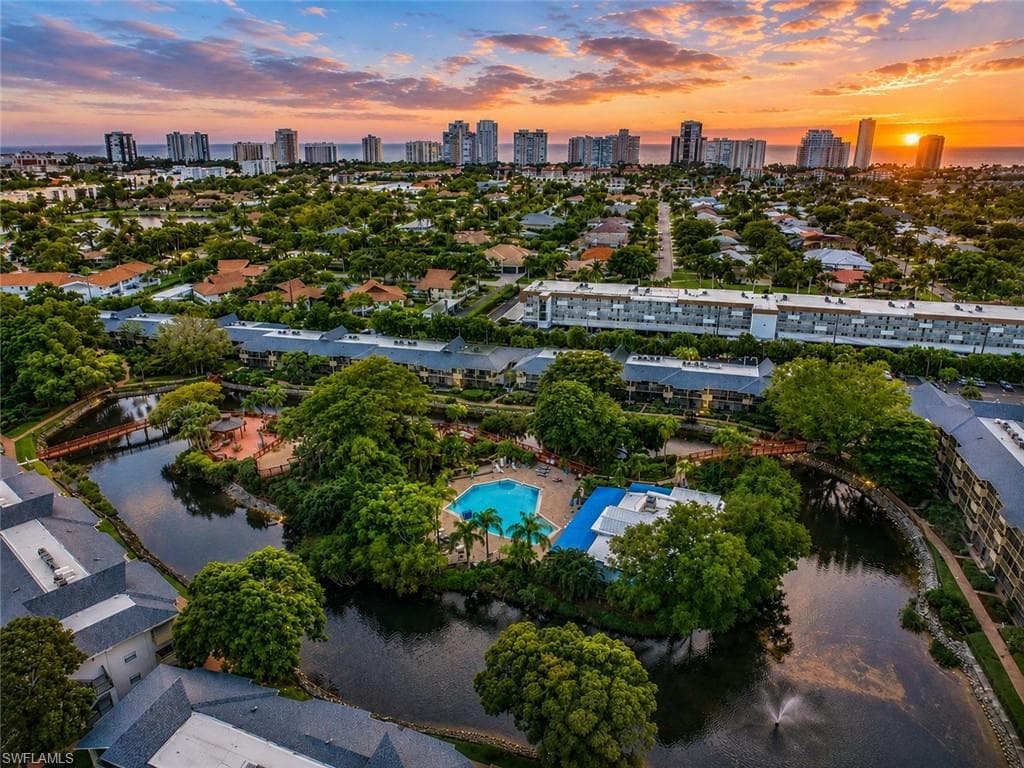 Community with multiple residential buildings, a central water feature, and extensive mature landscaping