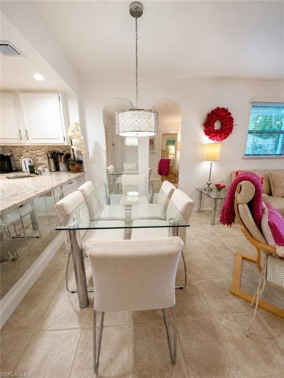 Dining area with tile flooring and a drum pendant light fixture