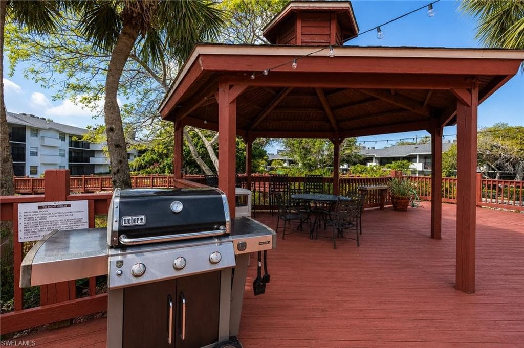 Expansive outdoor deck featuring a red-stained finish, a built-in gazebo structure, and perimeter railing