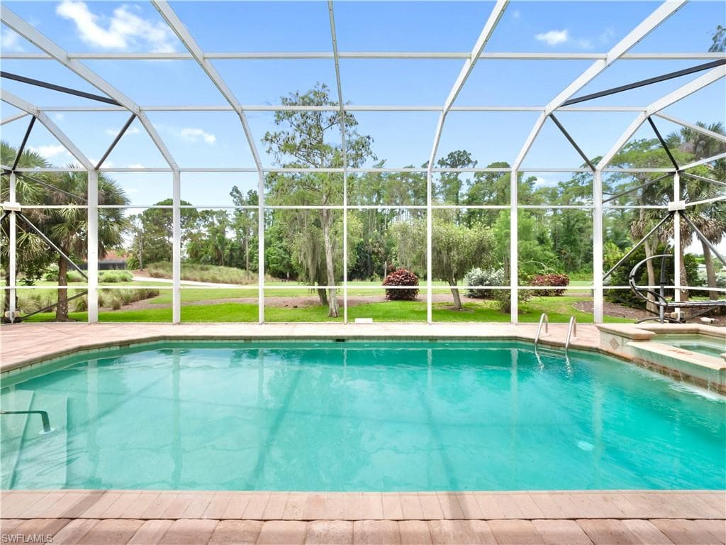 The large screened pool enclosure captures serene golf course views while preserving exceptional privacy through mature trees, generous setbacks, and one of Fiddlesticks' most unique homesites.