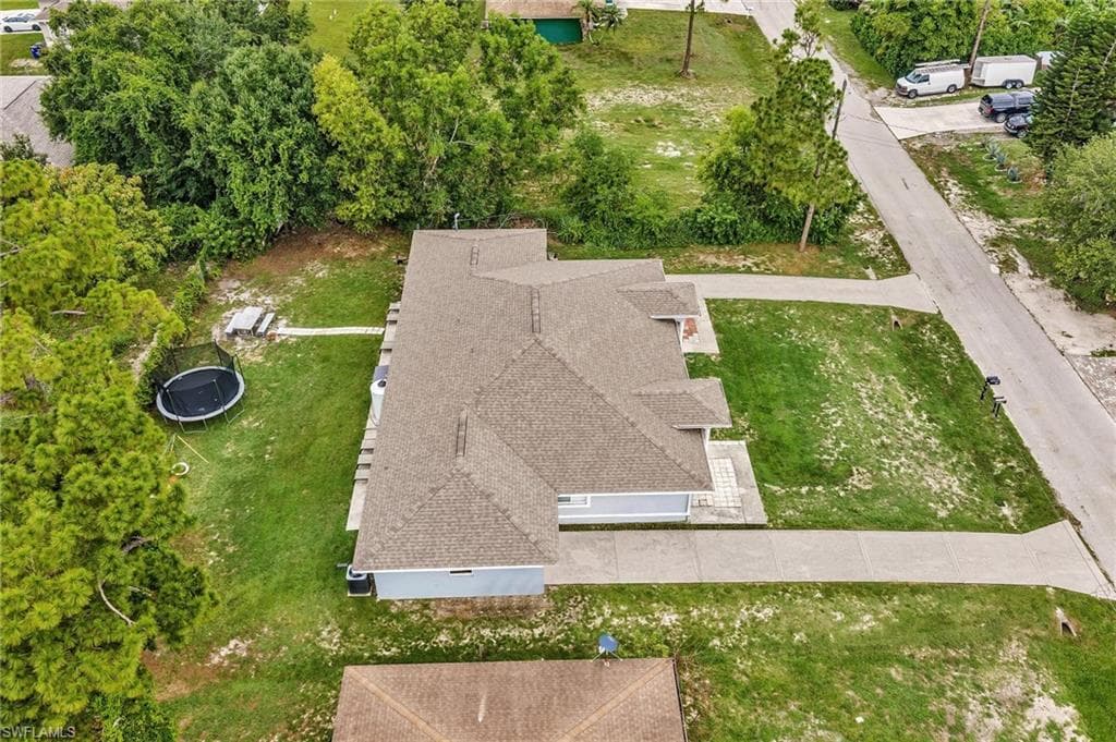 Spacious residential property featuring an asphalt shingle roof, light blue exterior siding, and a concrete driveway