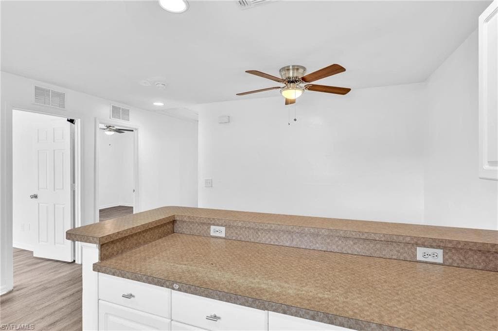 Kitchen island with a laminate countertop and white cabinetry