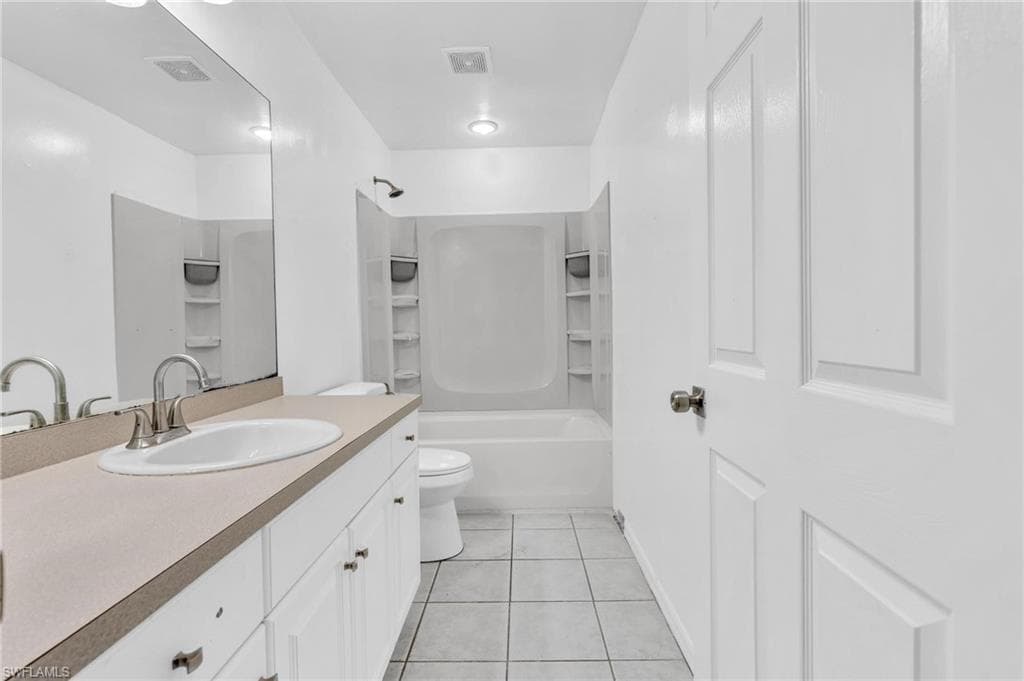 White vanity with integrated sink and brushed nickel faucet