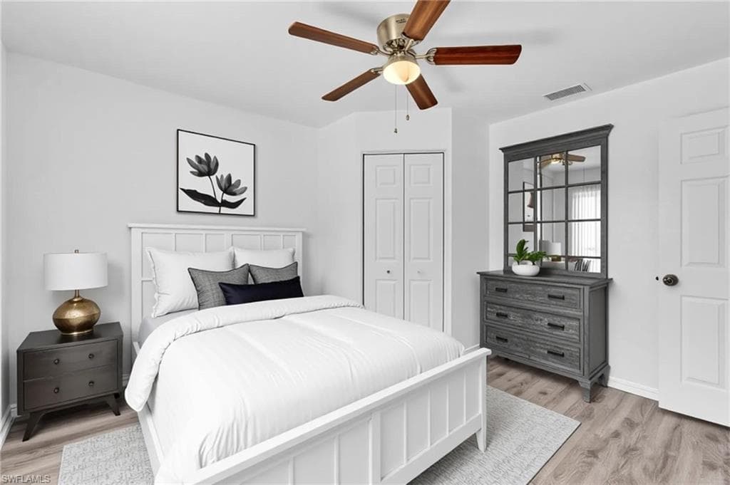 Light wood-finish flooring complements the neutral wall color in this room featuring a ceiling fan with integrated lighting