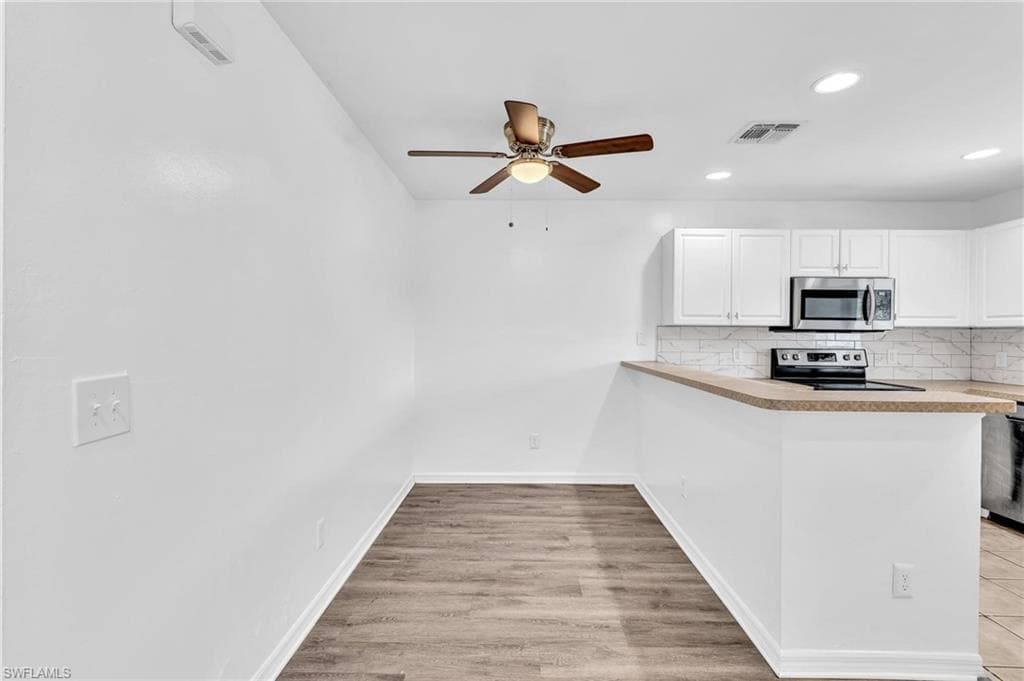 Dining area featuring wood-finish flooring and a ceiling fan with integrated lighting