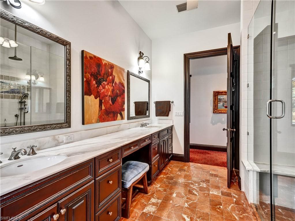 Expansive vanity with rich wood cabinetry, dual undermount sinks, and a light-toned countertop