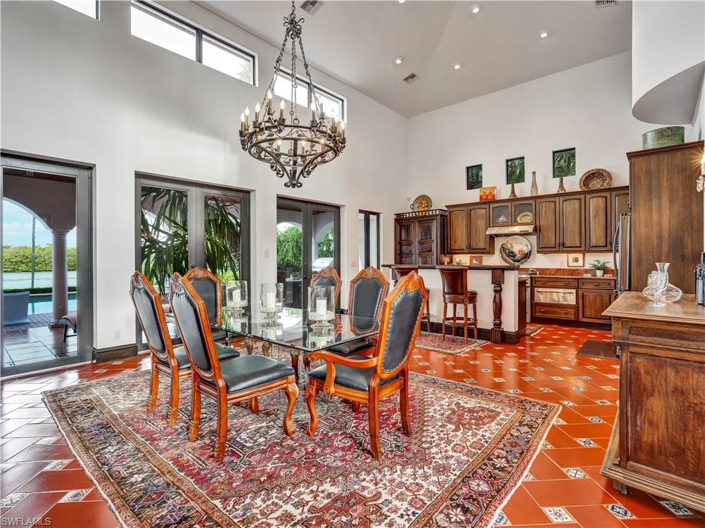 Formal dining space featuring terracotta tile flooring and a grand chandelier