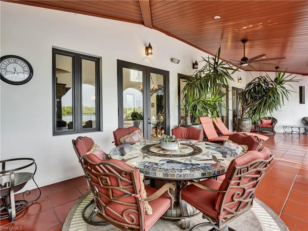 Expansive outdoor living area featuring a terracotta tile floor and a wood-paneled ceiling