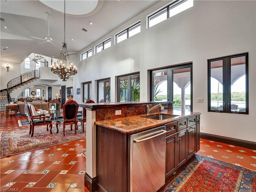 Wet bar featuring a dual-basin stainless steel sink, integrated dishwasher, and granite countertop
