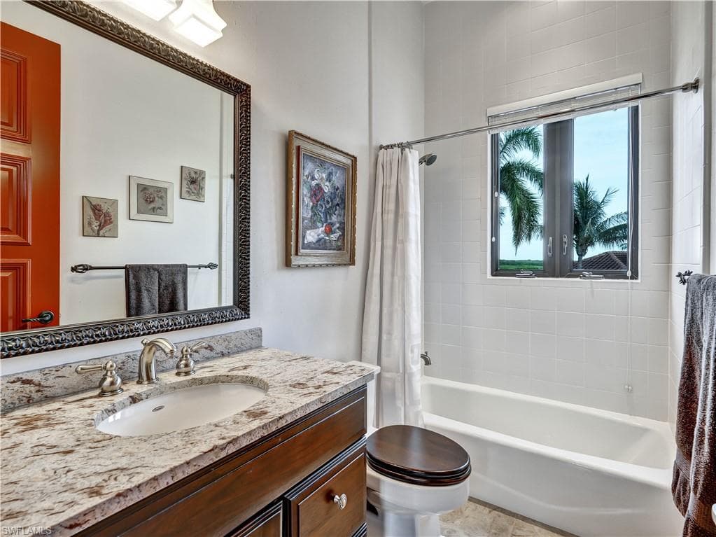 Bathroom featuring a vanity with a granite-style countertop, undermount sink, and brushed nickel fixtures