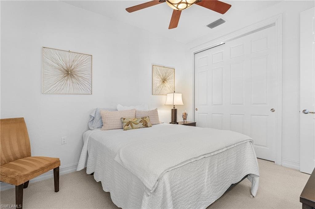 Bedroom featuring light carpet, a closet, baseboards, and a ceiling fan