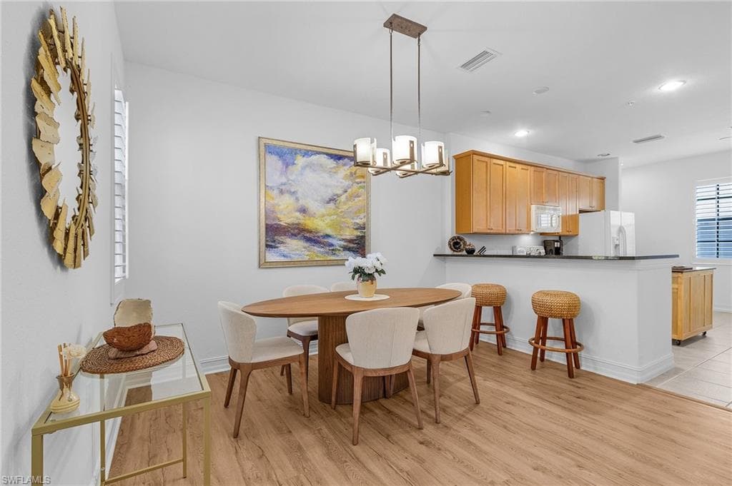 Dining area with light wood-style flooring, a chandelier, recessed lighting, and baseboards