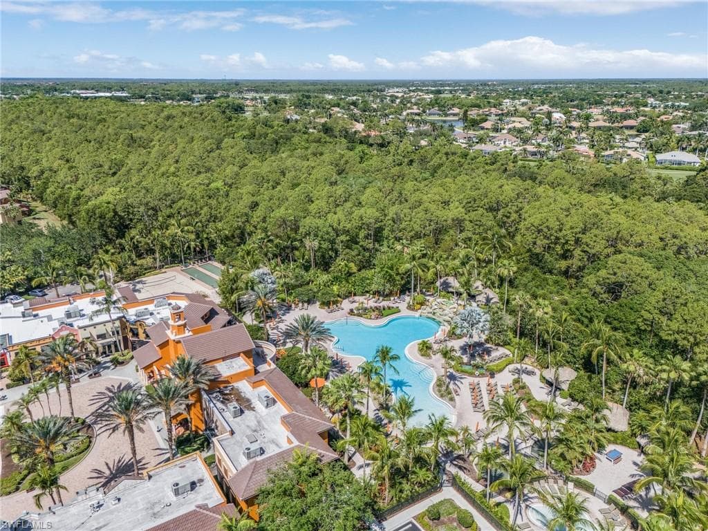Aerial view of property and surrounding area with a heavily wooded area and a pool area