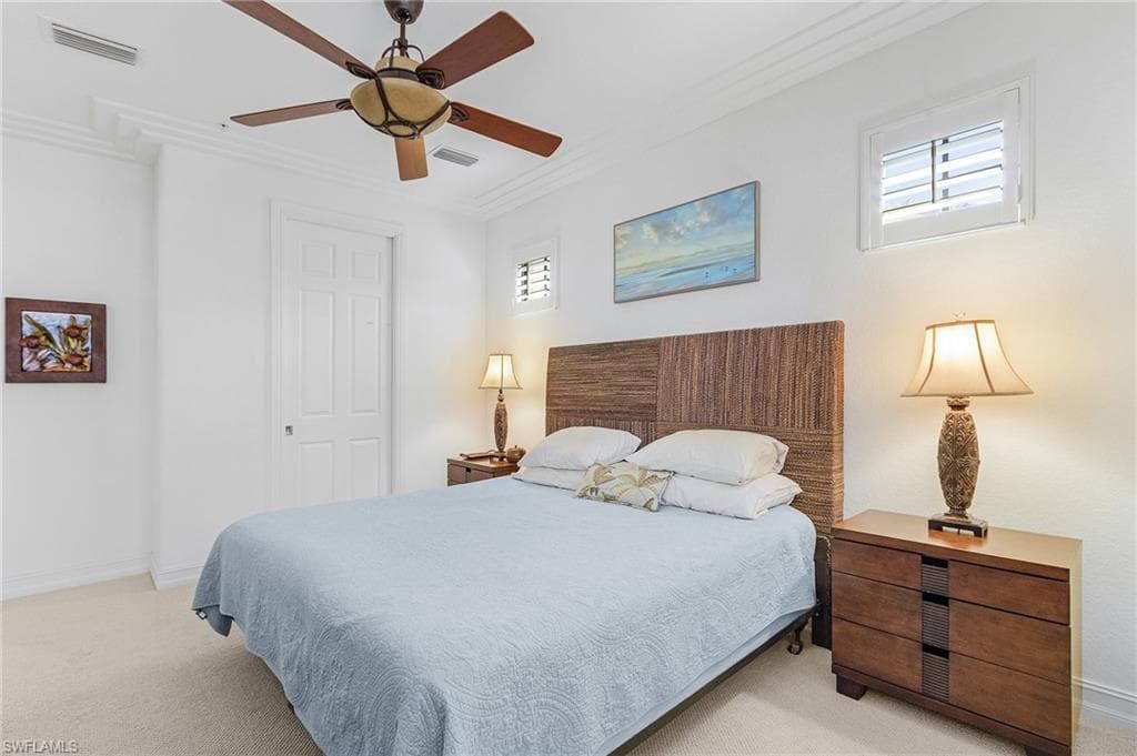 Bedroom featuring ornamental molding, light colored carpet, baseboards, and a ceiling fan