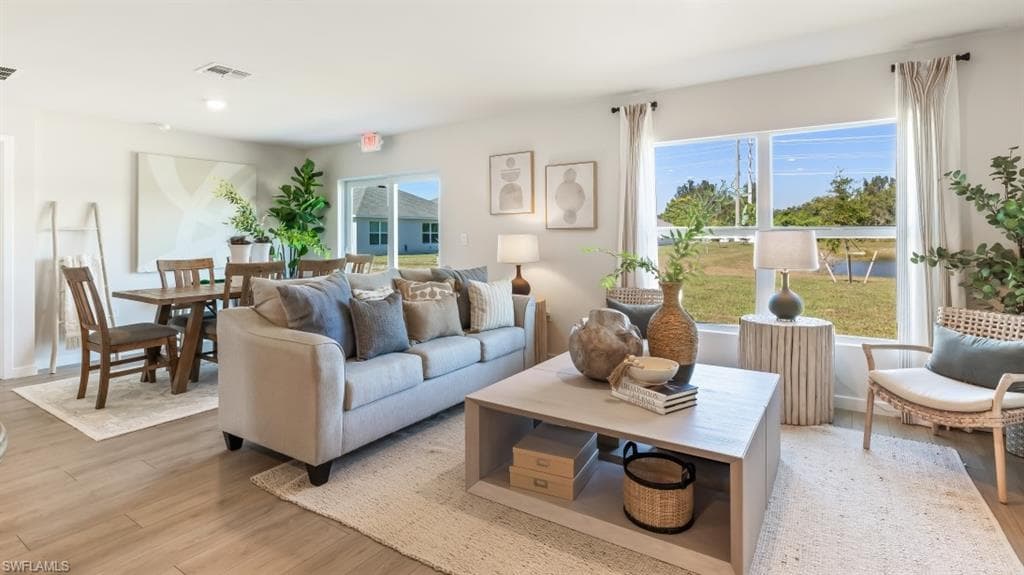 MODEL PHOTO - Living area with light wood-style flooring and healthy amount of natural light