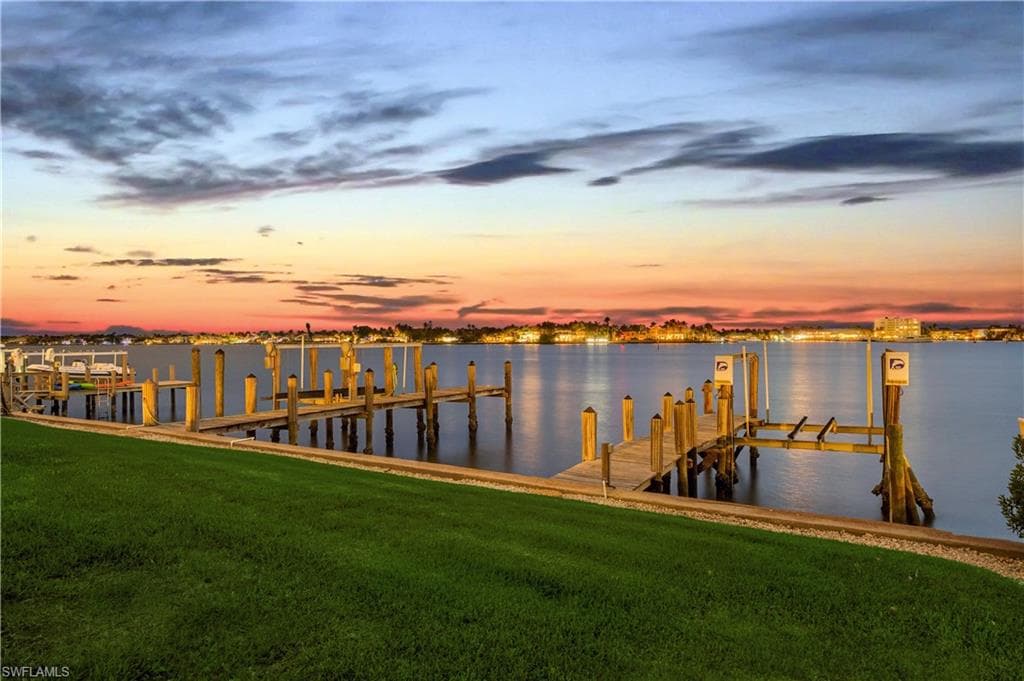 Dock featuring a lawn, boat lift, and a water view