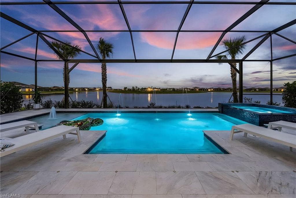 Integrated pool / hot tub with a water view, a sunroom, a lanai, and a patio area