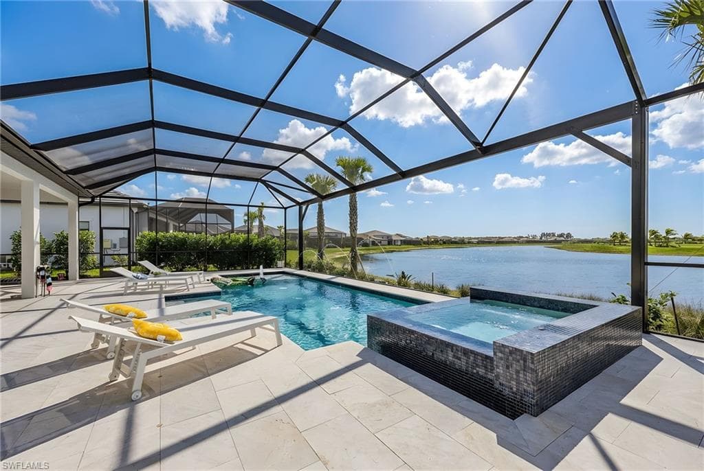 Relaxing pool / spa featuring a sunroom, glass enclosure, a water view, and a patio area