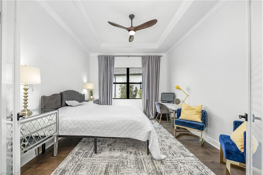 Bedroom featuring a raised ceiling, dark wood-style floors, ceiling fan, and crown molding