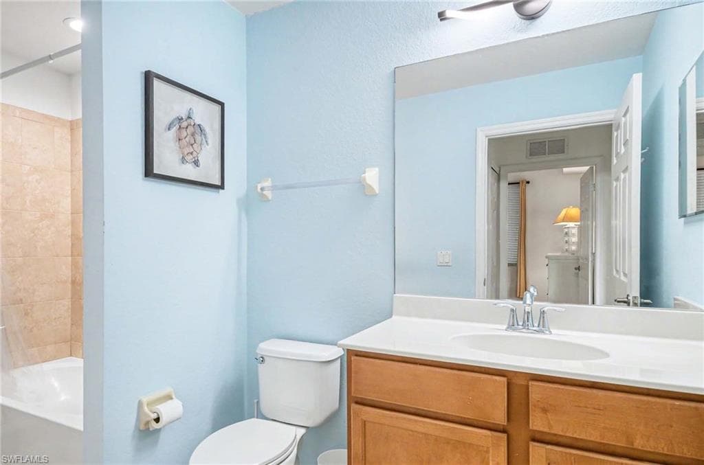 Main Bathroom with tub and shower just off the guest bedroom. Modern light fixture.
