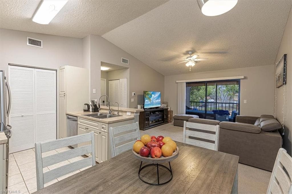 Kitchen with light countertops, open floor plan, a peninsula, a textured ceiling, and lofted ceiling