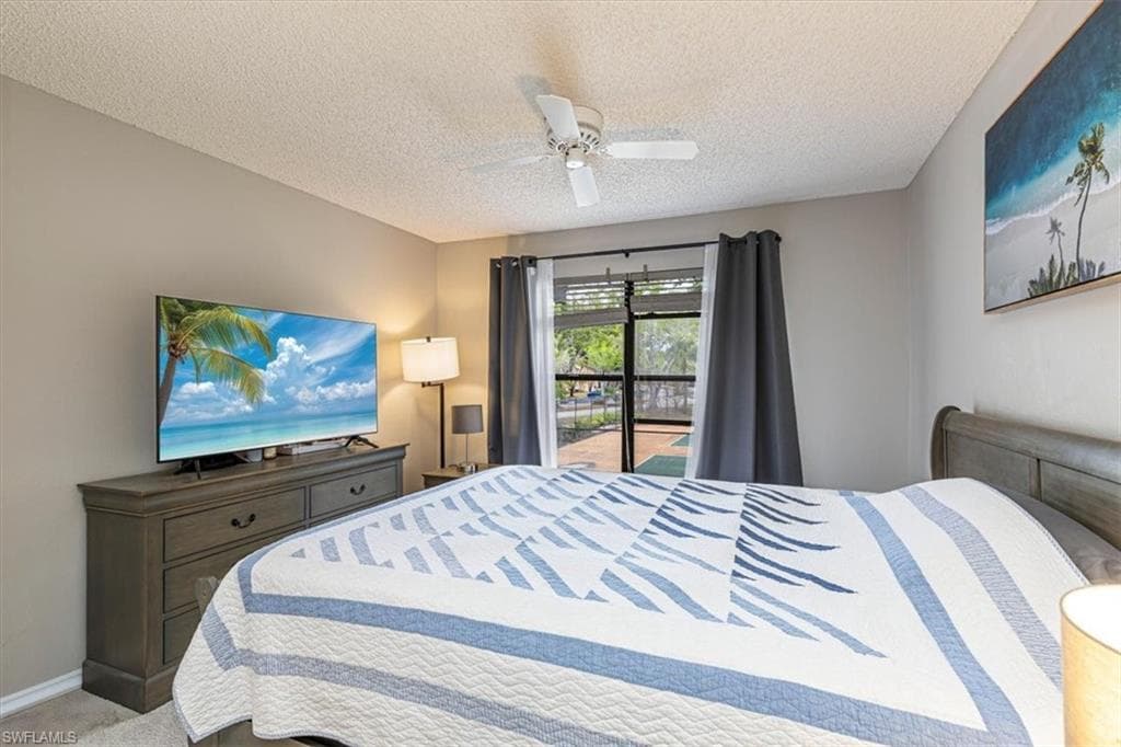 Bedroom with access to exterior, carpet, a ceiling fan, and a textured ceiling