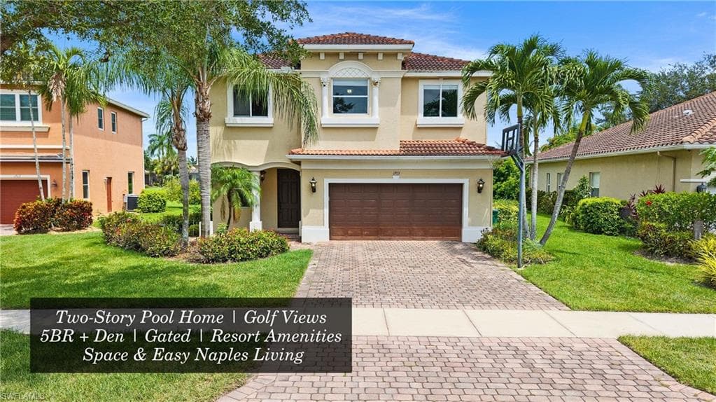 Two-story stucco residence featuring a tile roof and an arched entry