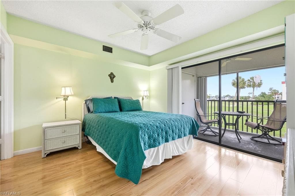 Room featuring wood-finish flooring, a ceiling fan, and direct access to an outdoor screened-in balcony