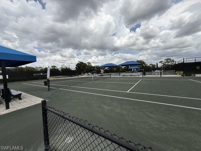 Tennis courts featuring a dark green surface with white line markings, surrounded by black chain-link fencing