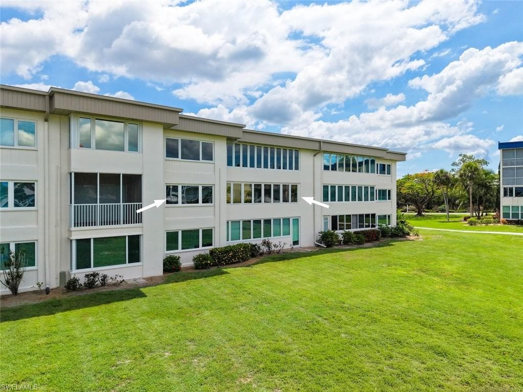 Back of the condo building featuring multiple windows
