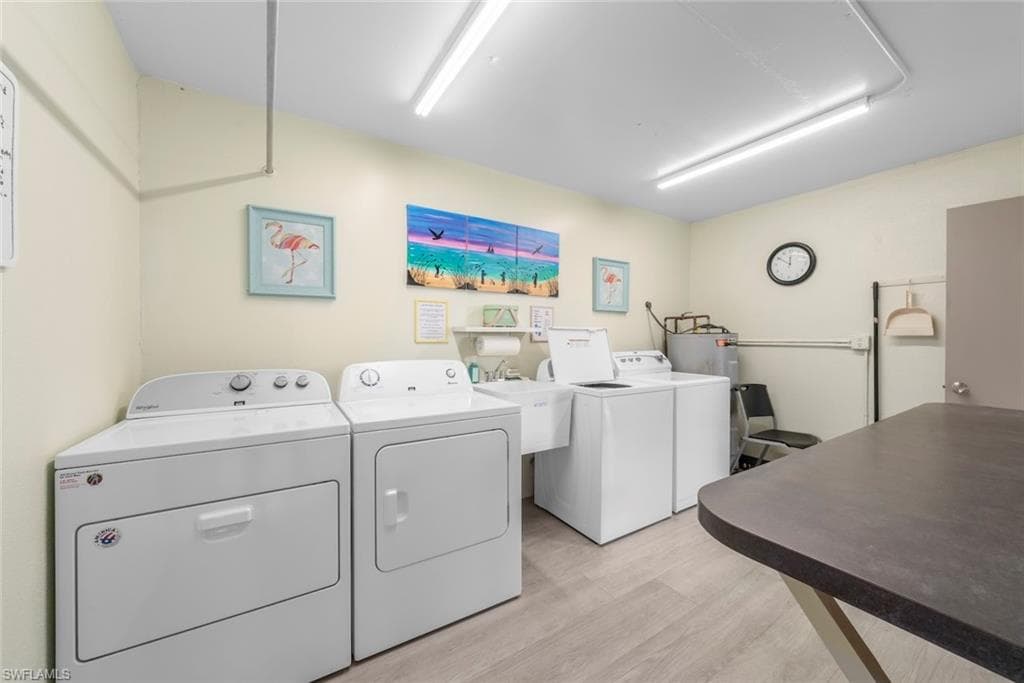 Dedicated laundry room featuring multiple washing machines and dryers, and utility sink.