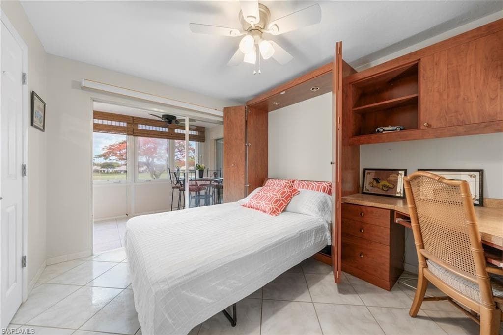 Guest bedroom with an integrated Murphy bed and desk unit with rich wood-finish cabinetry