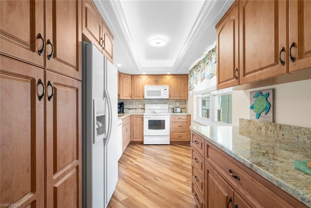 Kitchen featuring wood-finish flooring, wood cabinetry, and a tile backsplash