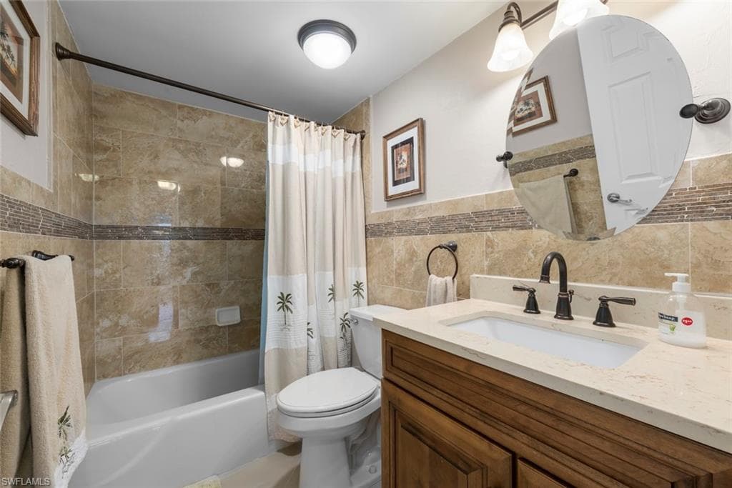 Bathroom featuring a sink with a light-toned countertop, a wood-finish vanity, and a shower and tub combination