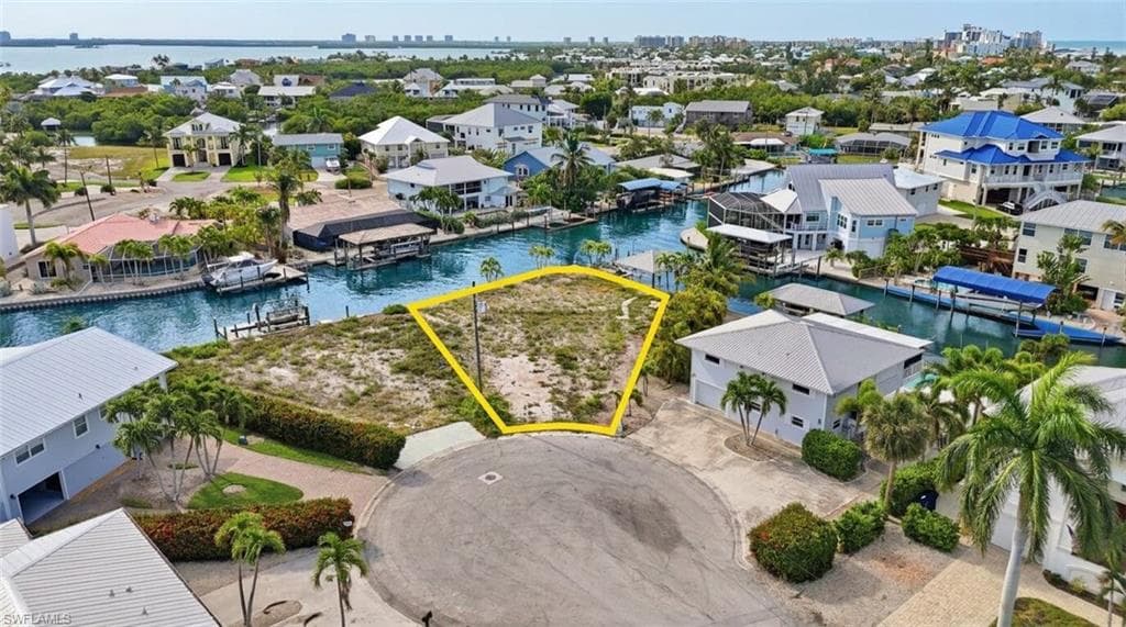 Waterfront lot featuring direct canal access, a cul-de-sac location, and surrounding mature tropical landscaping - Virtually Edited Image