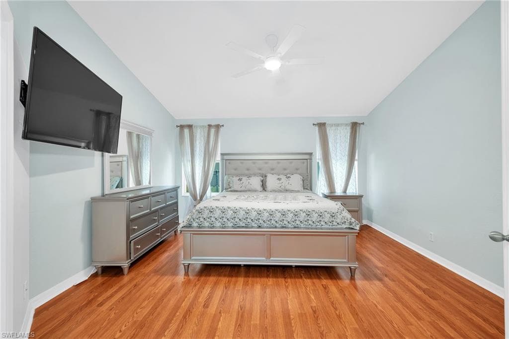 Spacious room featuring wood-finish flooring, a ceiling fan, and light-toned walls